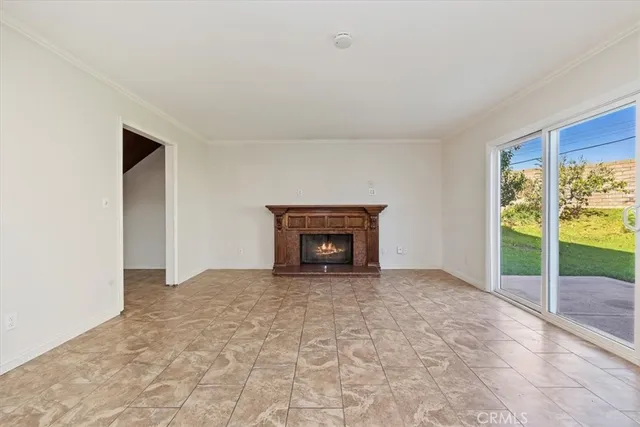 a view of an empty room with a fireplace and a window