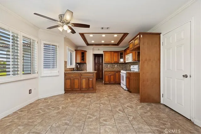 a kitchen with granite countertop a refrigerator and stainless steel appliances