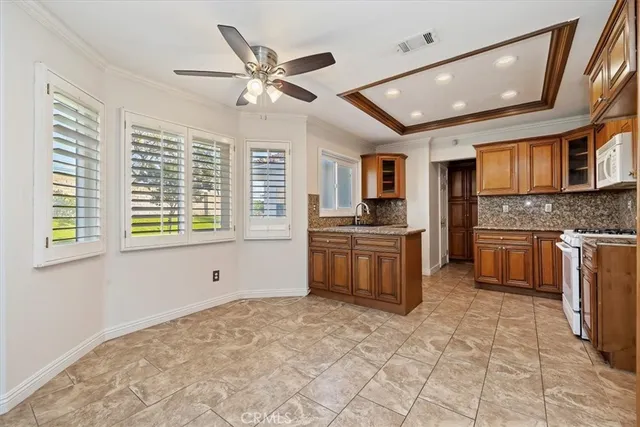a kitchen with granite countertop a stove sink and cabinets