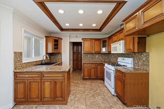 a kitchen with stainless steel appliances granite countertop a stove sink and cabinets