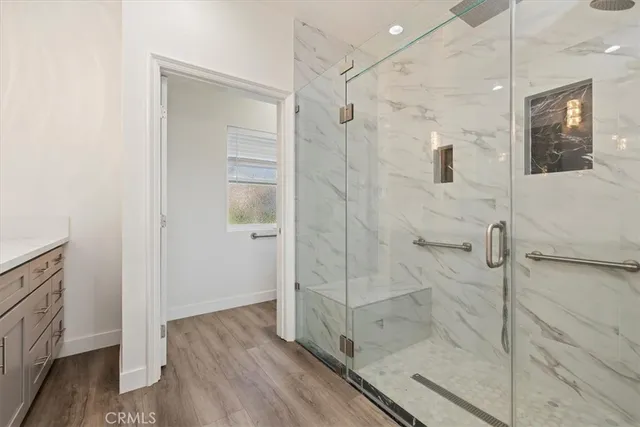 a bathroom with a glass shower door and a bathtub