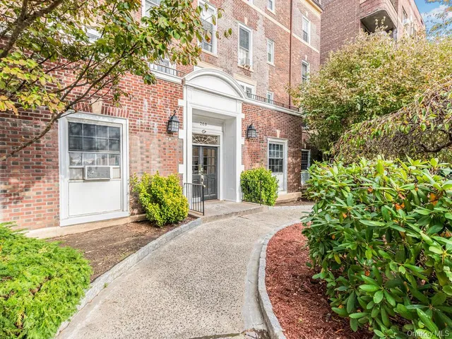 front view of a brick house with a yard