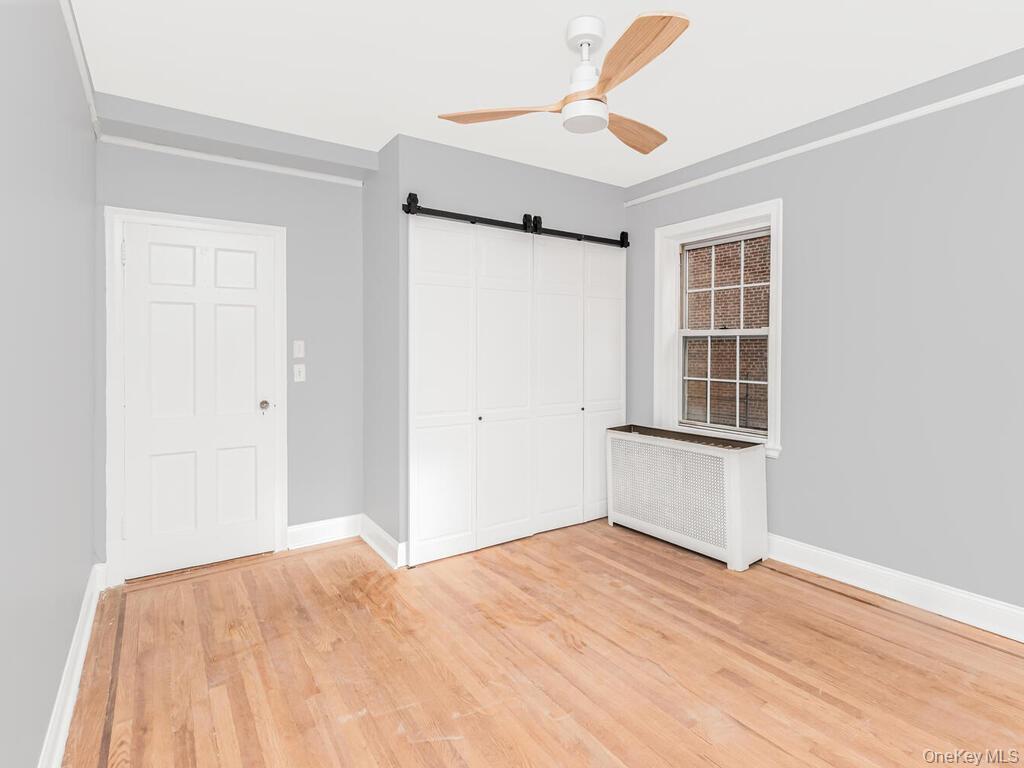208 Centre Avenue, Unit 5K New Rochelle, NY 10805 - Photo 8 of 10 a view of empty room with wooden floor and fan