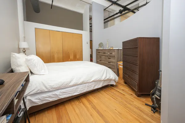 a bedroom with a bed and wooden floor