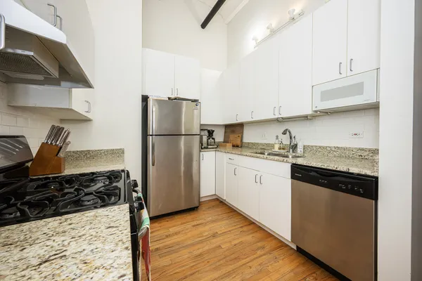 a kitchen with a refrigerator stove and white cabinets