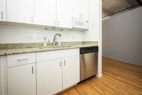 a kitchen with stainless steel appliances granite countertop a sink and a refrigerator
