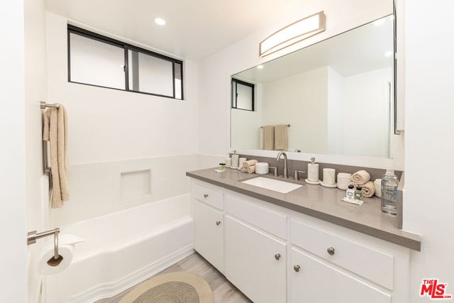 a bathroom with a shower sink and mirror