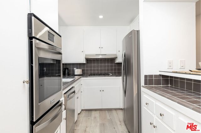 a kitchen with stainless steel appliances a refrigerator and a stove