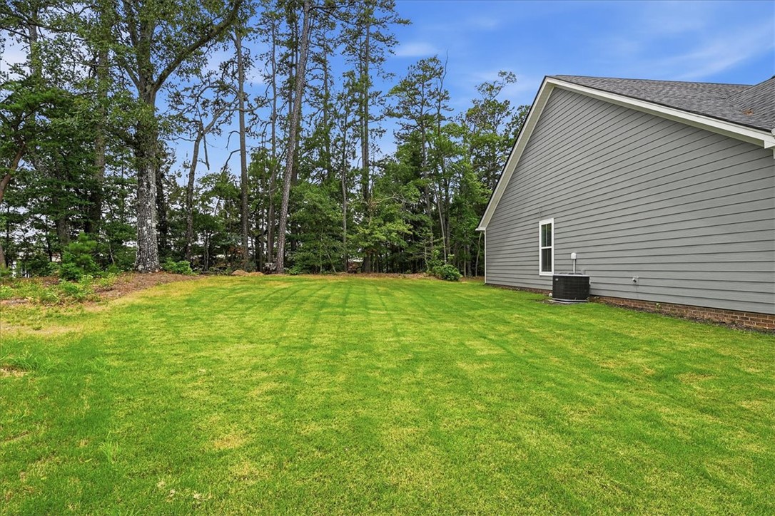 214 Timothy Court Anderson, SC 29621 - Photo 37 of 43 A pristine backyard with ample green space bordered by natural woodlands, perfect for outdoor enjoyment.