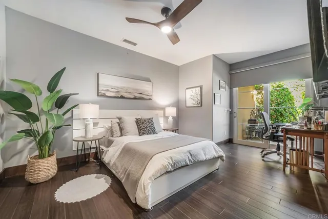 a bedroom with a large bed and a potted plant