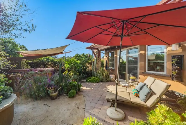 a view of patio with chairs and table under an umbrella