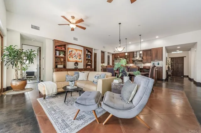 a living room with furniture kitchen view and a large window