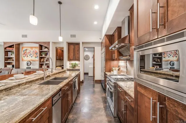 a kitchen with stainless steel appliances granite countertop a stove and a sink