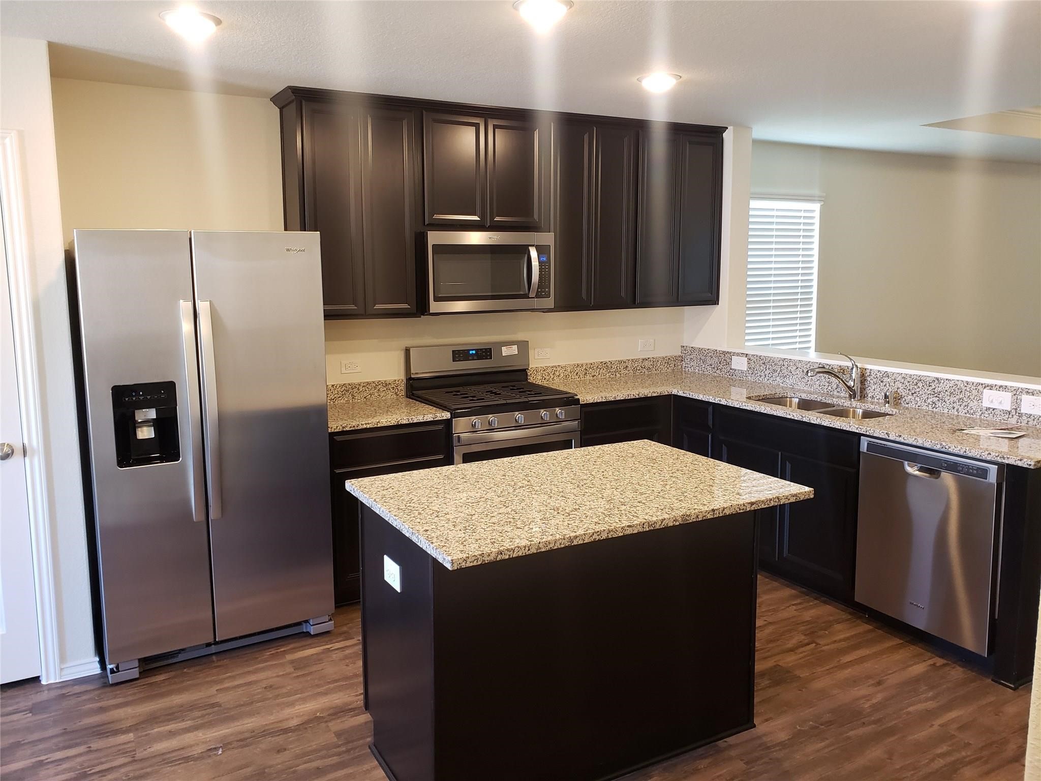 24006 Swather Way Hockley, TX 77447 - Photo 7 of 20 a kitchen with stainless steel appliances granite countertop wooden cabinets a refrigerator and a sink