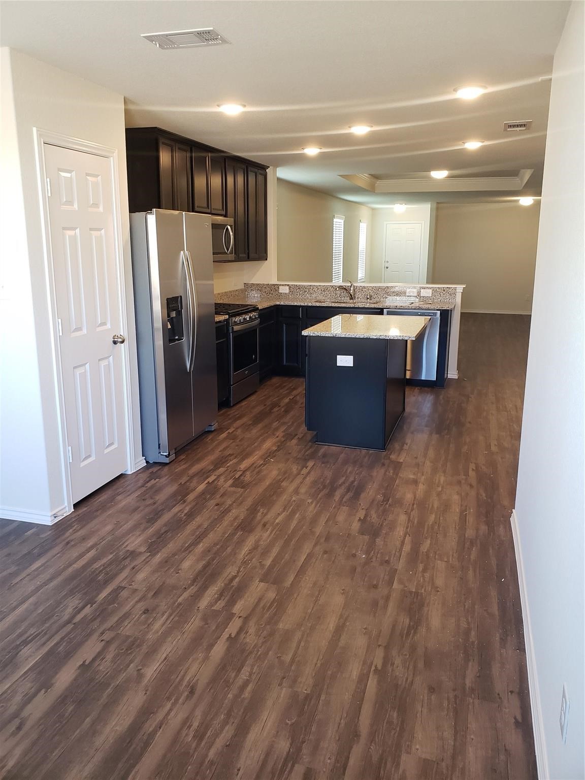 24006 Swather Way Hockley, TX 77447 - Photo 8 of 20 a kitchen with stainless steel appliances kitchen island granite countertop a refrigerator and a sink