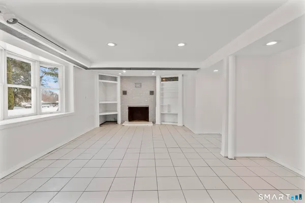 a view of empty room with wooden floor and fireplace