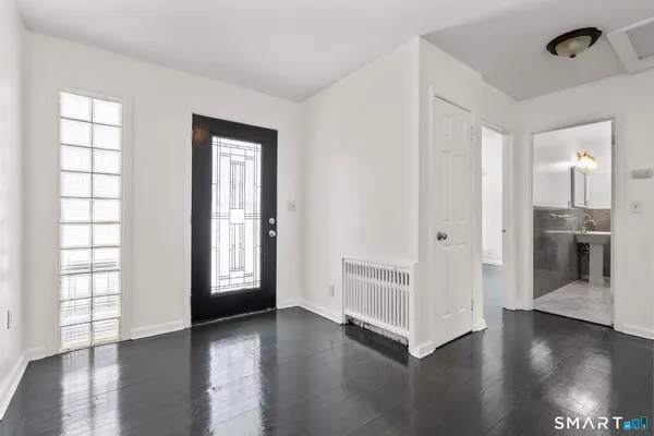 a view of an empty room with window and wooden floor