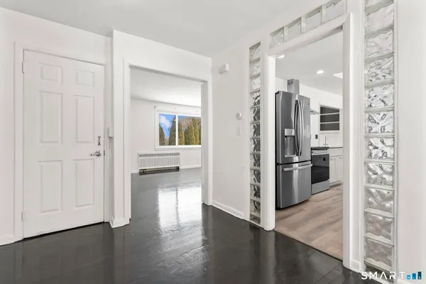 a view of a kitchen with a refrigerator and a stove top oven