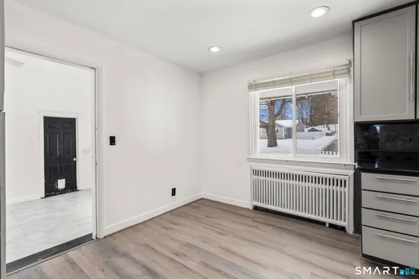 a view of a hallway with wooden floor and windows