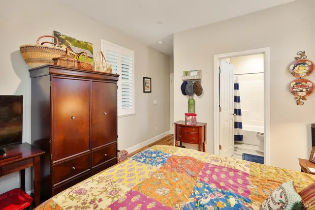 a bedroom with a bed and a flat tv screen on dresser