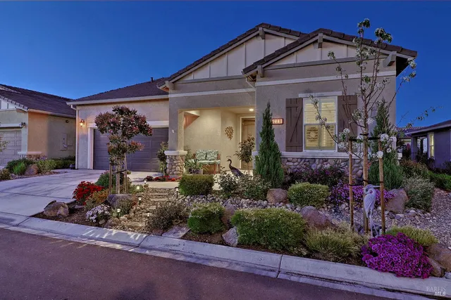 a view of a house with a small yard and potted plants