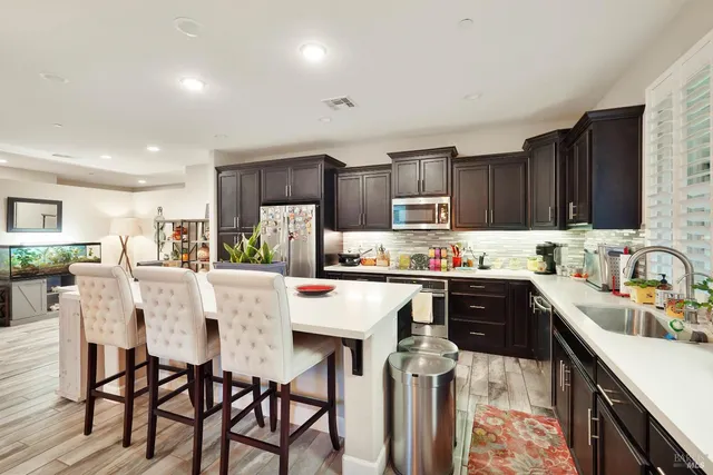 a kitchen with stainless steel appliances kitchen island granite countertop a sink and cabinets