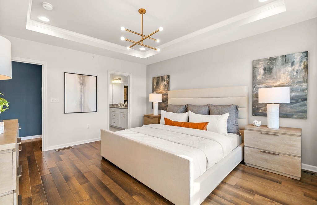 2 Cooley Drive, Unit 15 Woburn, MA 01801 - Photo 13 of 34 a bedroom with a large bed and a chandelier