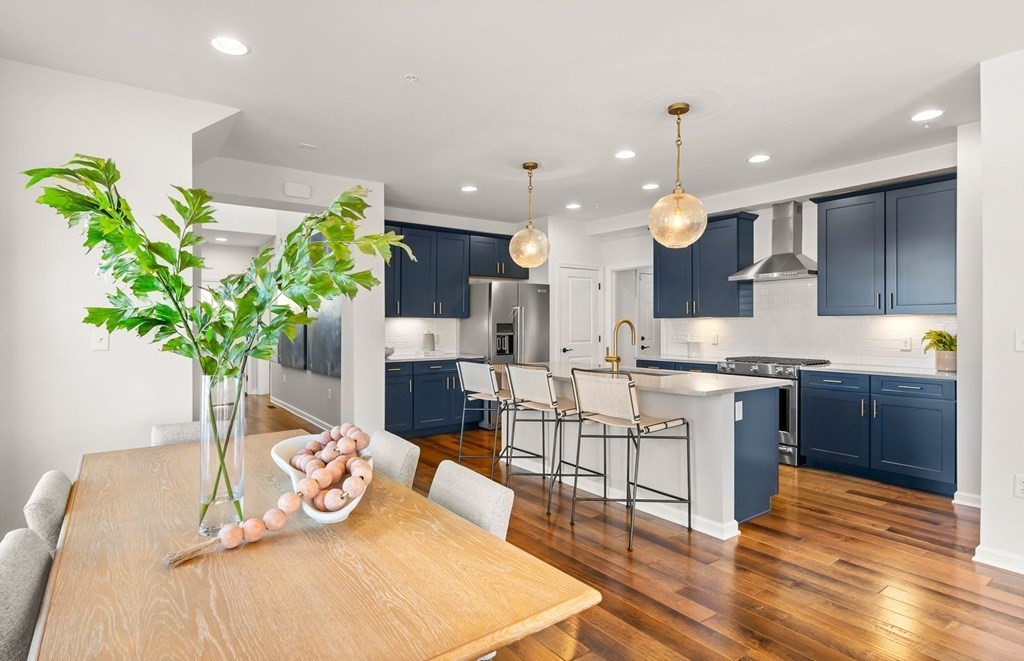 2 Cooley Drive, Unit 15 Woburn, MA 01801 - Photo 3 of 34 a kitchen with stainless steel appliances kitchen island granite countertop a sink a counter space and wooden floor