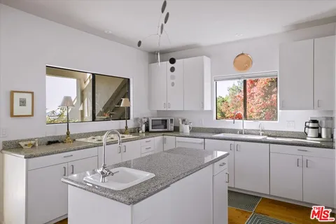 a bathroom with a granite countertop sink and a window