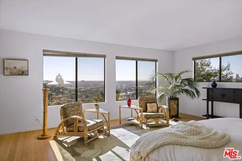 a living room with furniture and floor to ceiling windows