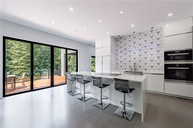 a kitchen with granite countertop white cabinets and stainless steel appliances