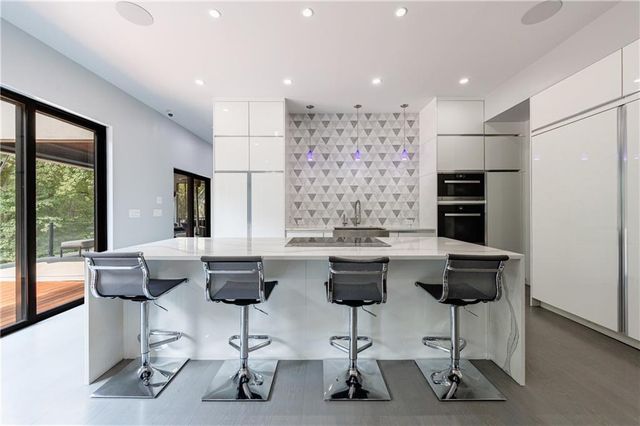 a large kitchen with kitchen island a sink table and chairs