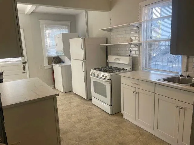 a kitchen with a stove top oven and refrigerator