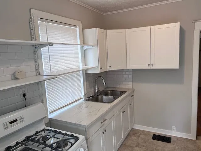 a kitchen with white cabinets and a stove
