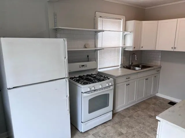 a kitchen with white cabinets and white appliances