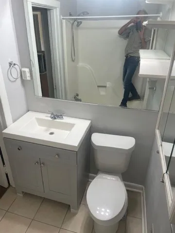 a bathroom with a toilet sink and mirror