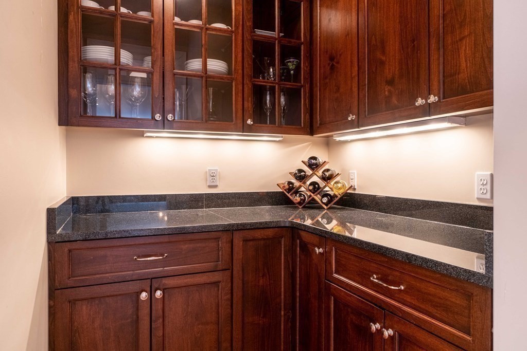 157 Walpole Street Dover, MA 02030 - Photo 14 of 38 a sink with granite countertop wooden cabinets