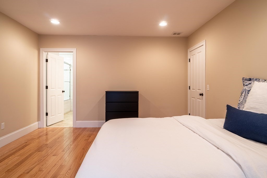 157 Walpole Street Dover, MA 02030 - Photo 30 of 38 a bedroom with a large bed and wooden floor