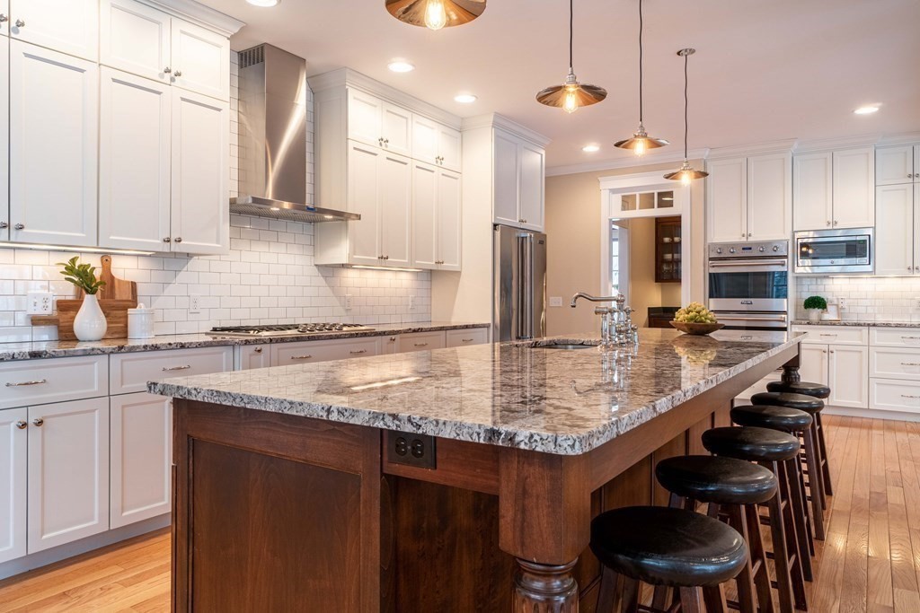 157 Walpole Street Dover, MA 02030 - Photo 7 of 38 a kitchen with kitchen island granite countertop a sink a center island stainless steel appliances and cabinets