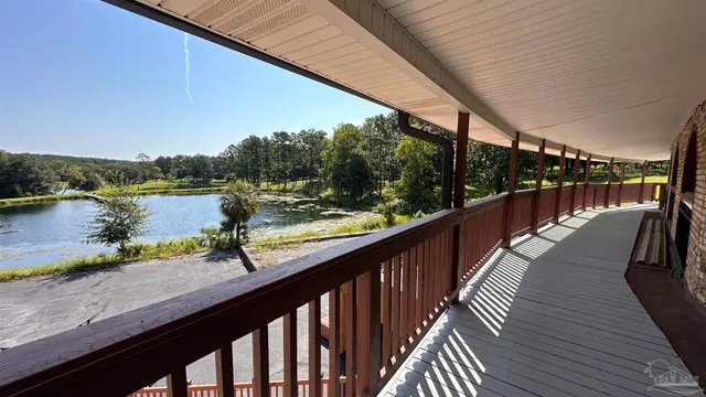 a balcony with wooden floor and lake view
