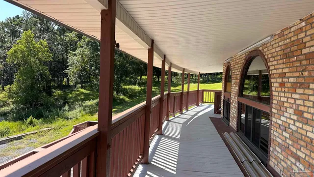a view of balcony with wooden floor and fence