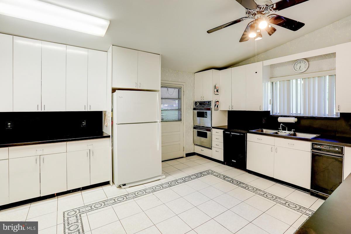 6206 Ivymount Road Baltimore, MD 21209 - Photo 23 of 25 a kitchen with stainless steel appliances granite countertop a refrigerator a stove a sink and white cabinets