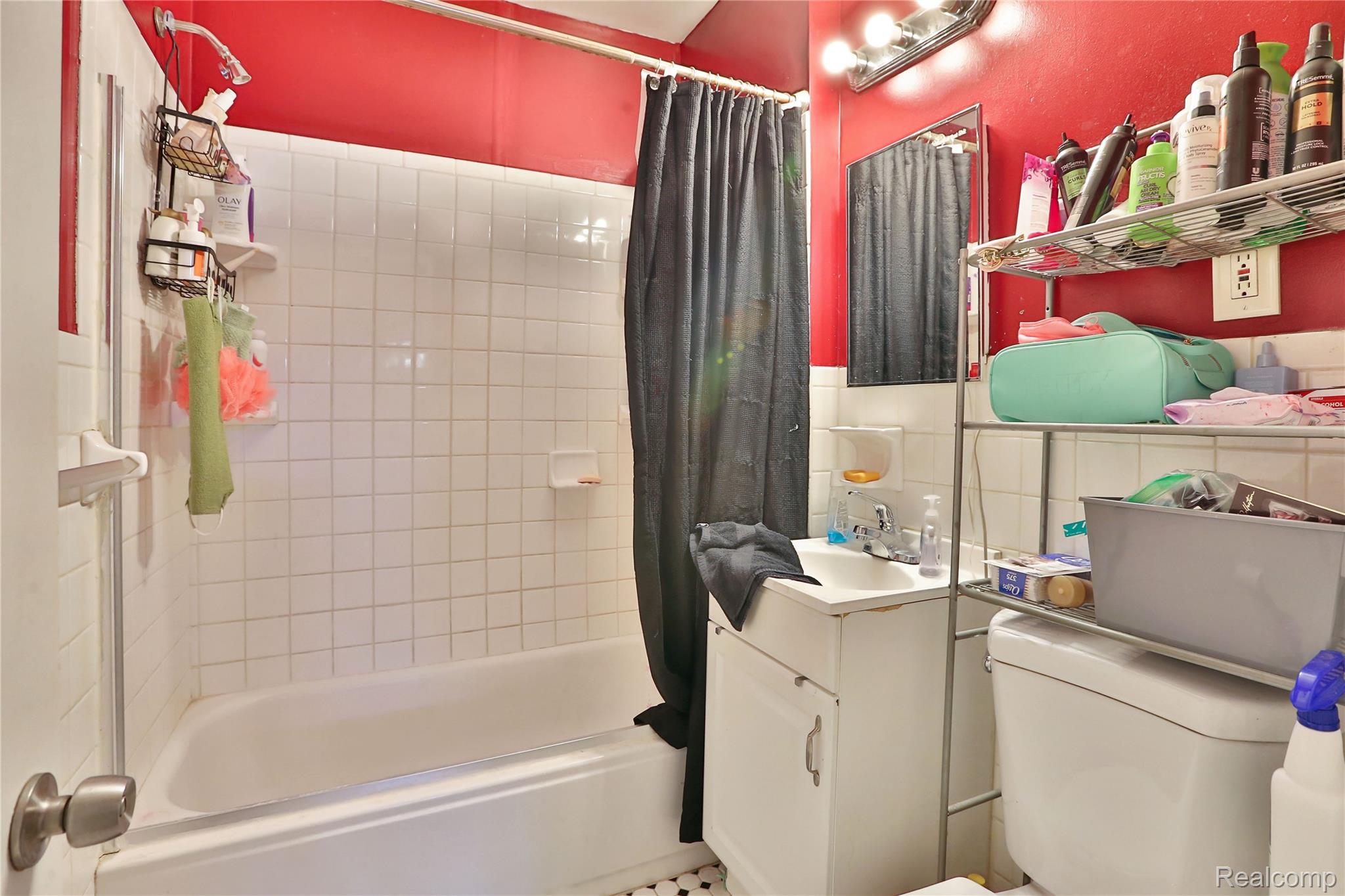 17204 Stephens Road Eastpointe, MI 48021 - Photo 8 of 11 Bathroom featuring vanity, shower / bath combination with curtain, and tile walls