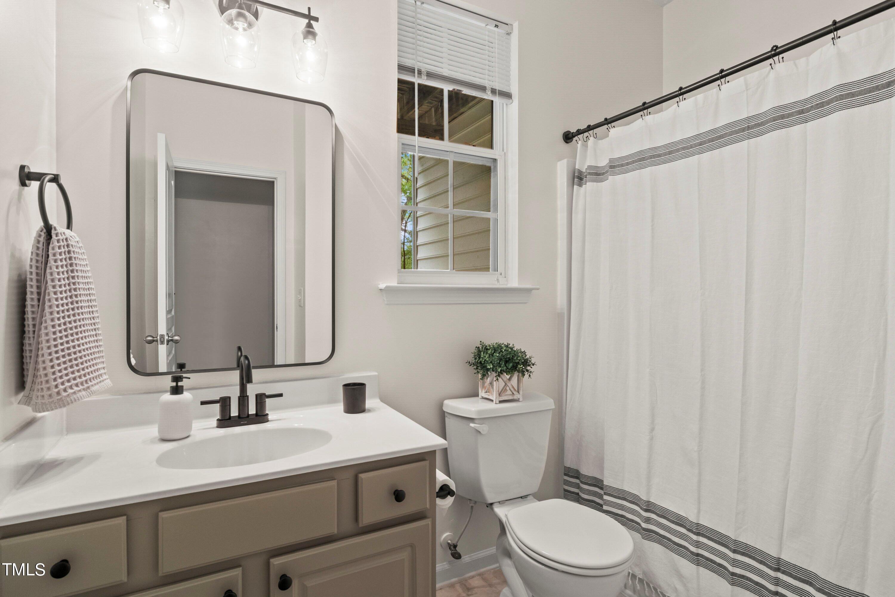 5476 Crescentview Parkway Raleigh, NC 27606 - Photo 28 of 36 Lower level full bath with updated light fixture, plumbing fixuture & mirror.