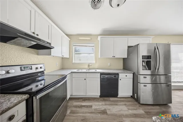 a kitchen with a stove sink and refrigerator