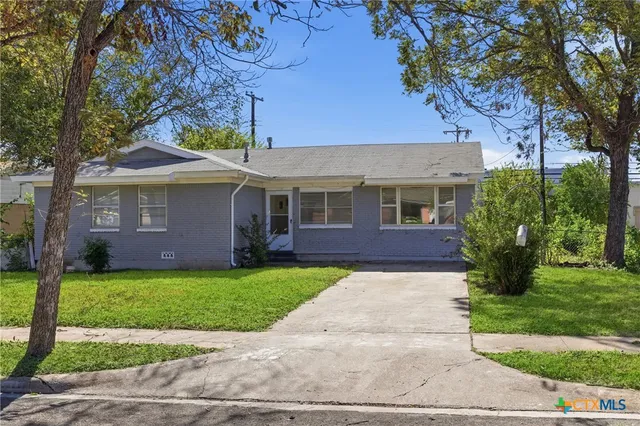 a front view of a house with a garden and yard