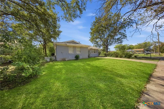 a view of a house with yard and tree s