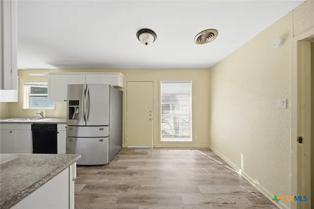 a kitchen with refrigerator and window