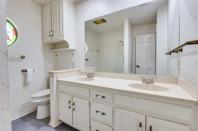 a bathroom with a toilet sink and mirror