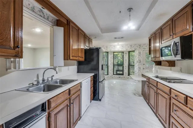a kitchen with stainless steel appliances a sink stove and cabinets